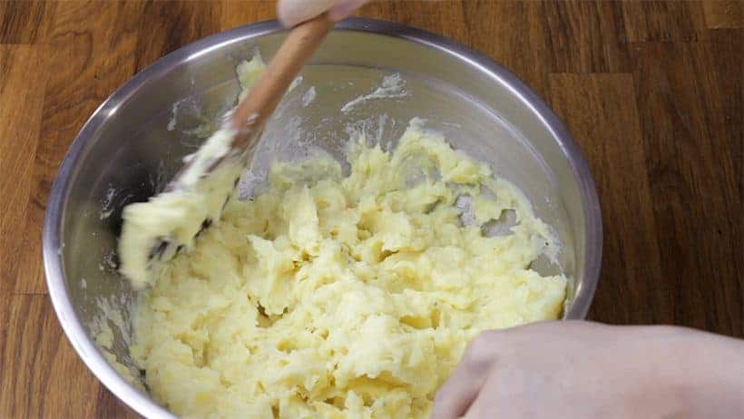 mashing instant pot potatoes with wooden spoon